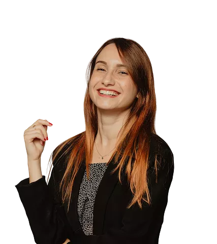 A woman with copper-toned straight hair, red lipstick, wearing a black blazer over a patterned top—smiling confidently against a clean black background.