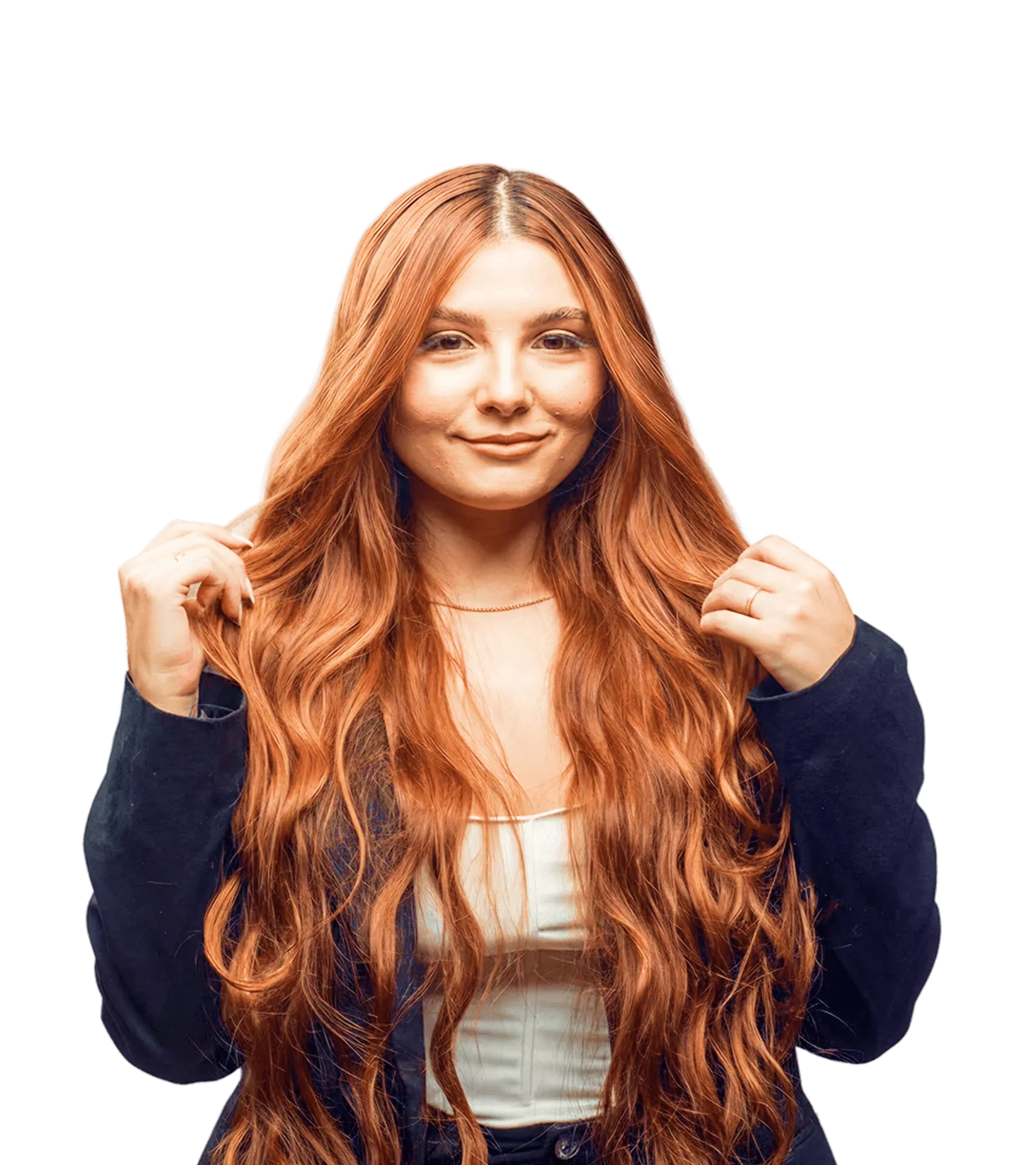 Woman with long copper-red wavy hair wearing navy blazer, smiling confidently against black background studio portrait