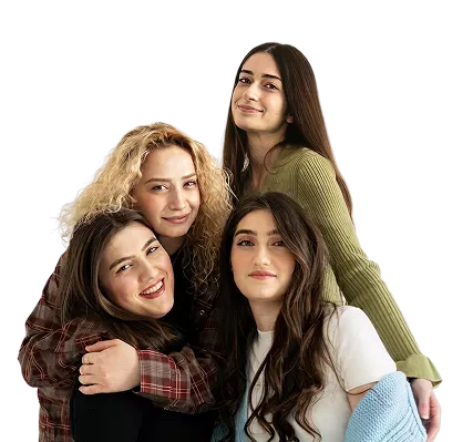 Four young women with different hair textures smiling and posing together against a muted purple background.