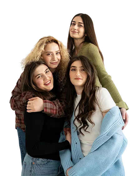 Four young women with different hair textures smiling and posing together against a muted purple background.